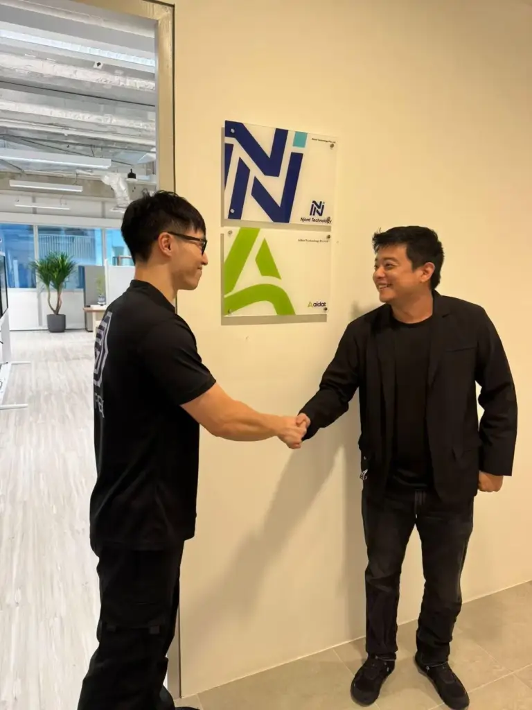 Mofex team member shaking hands with a business client in an office reception