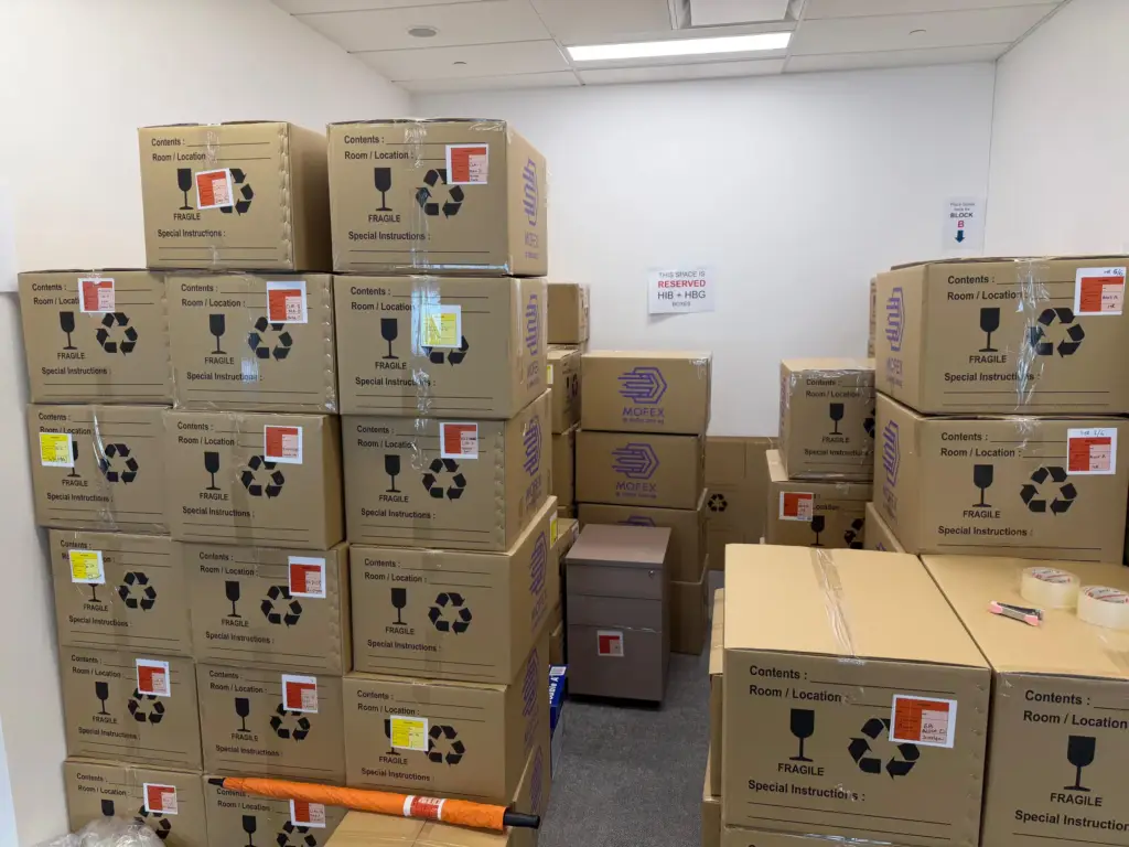 Stacked Mofex moving cartons labelled for an office relocation