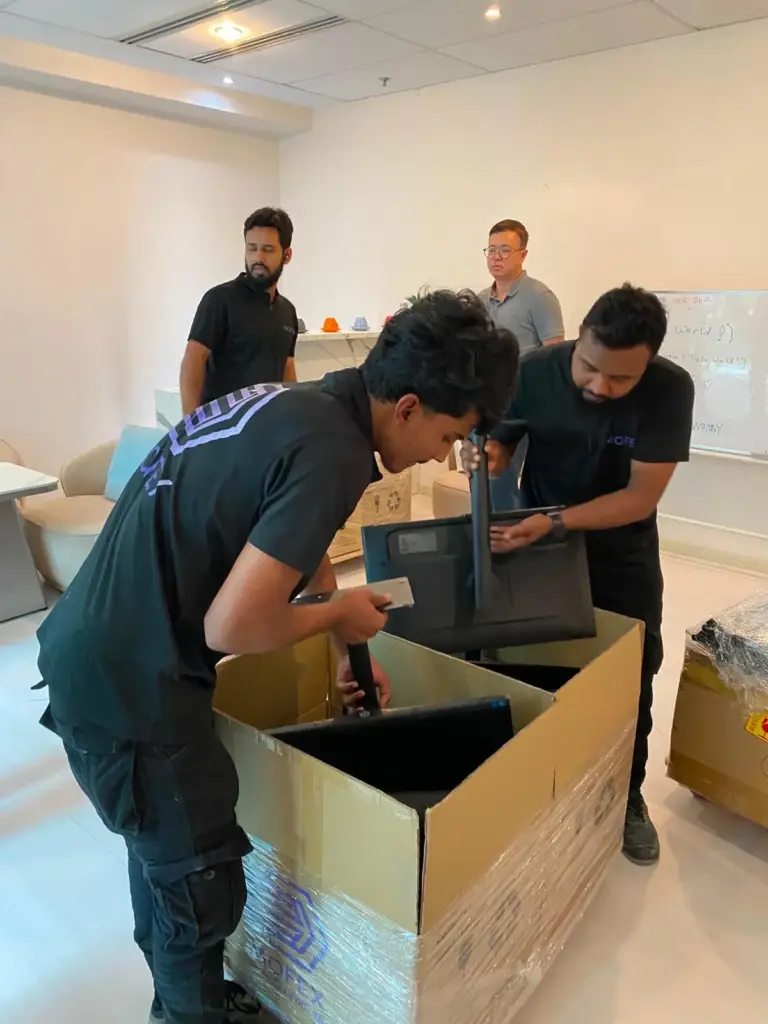 Mofex crew packing computer monitors into a carton