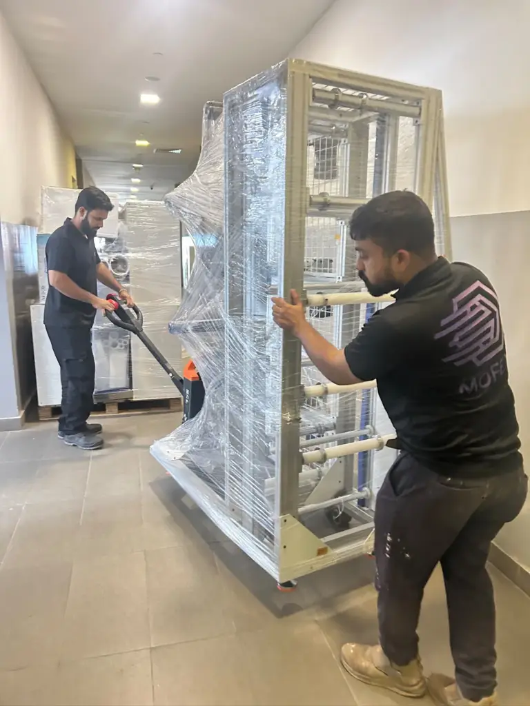 Mofex mover wheeling a stretch-wrapped lab rack down a corridor